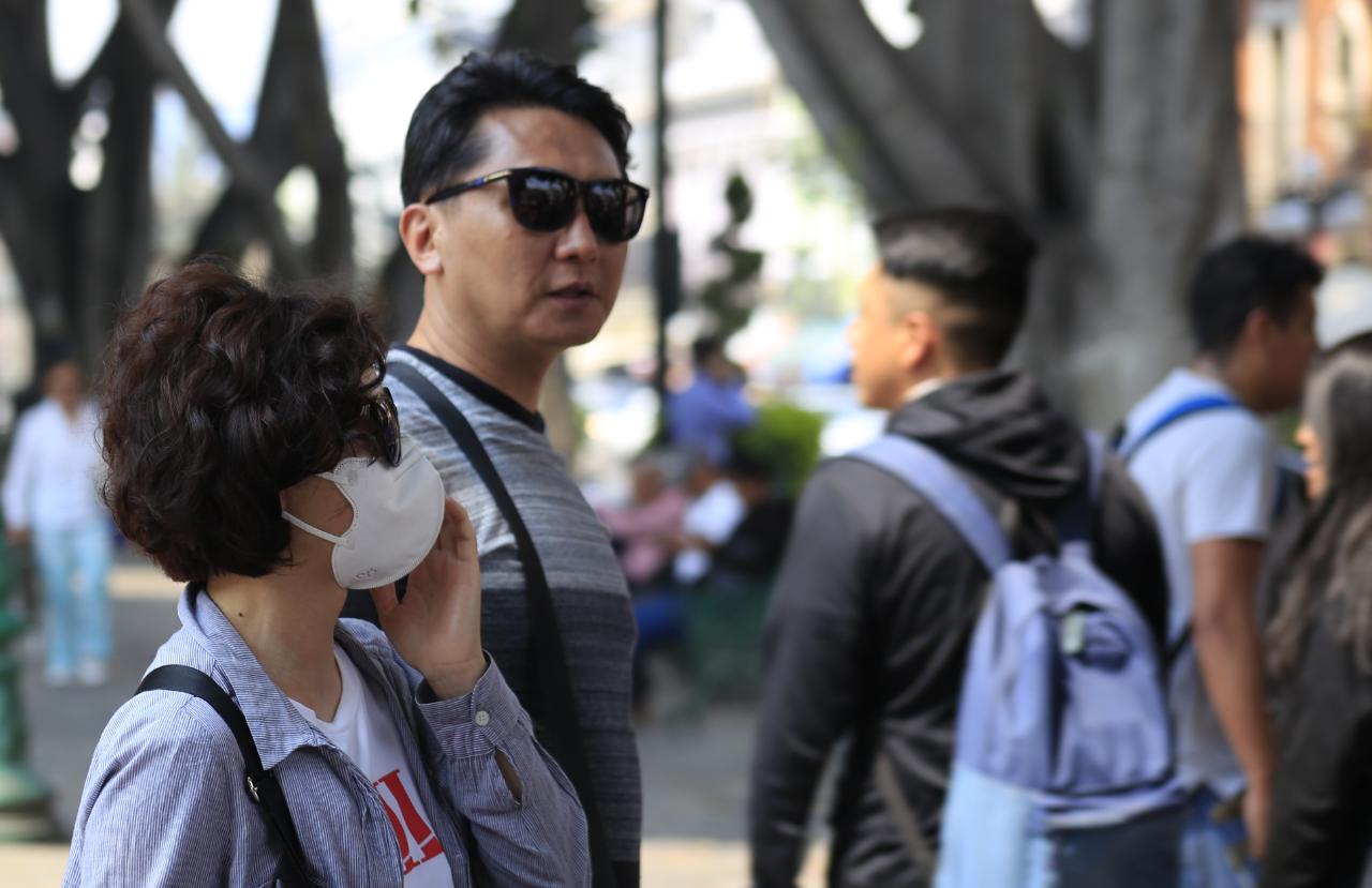 Turistas que pasean por el centro histórico de Puebla se protegen de la contaminación usando cubrebocas (Andrés Lobato )