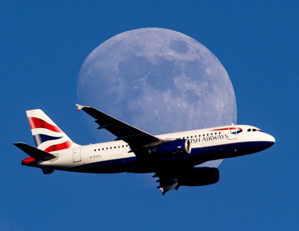 Alemania. Un avión de British Airways es fotografiado junto a la luna llena en Fráncfort (AP)