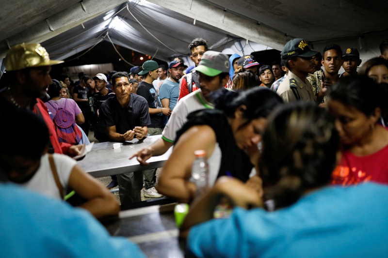 Venezolanos esperan en fila para vacunarse en el puesto fronterizo entre Perú y Ecuador en las afueras de Tumbes, Perú. (Reuters)