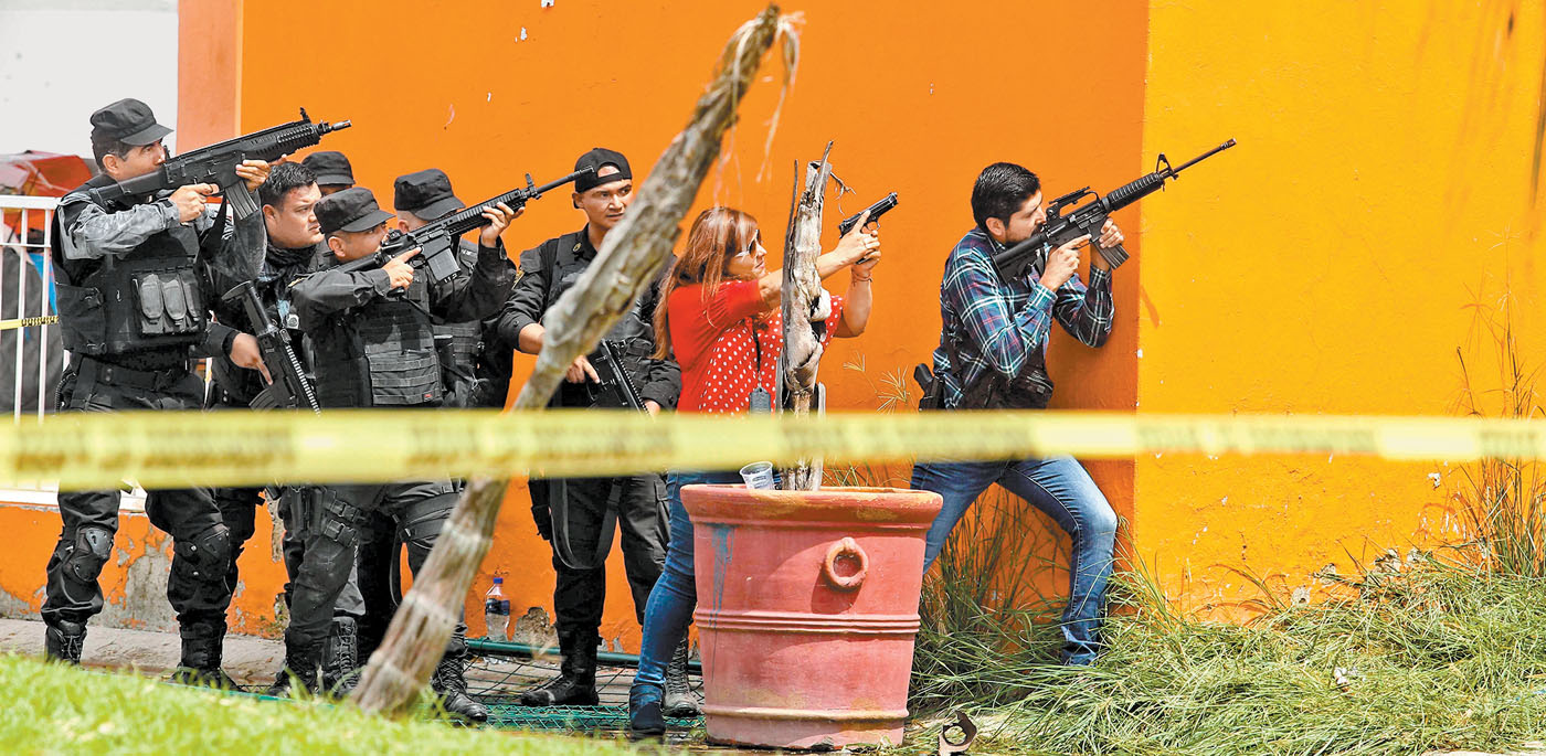 Policías apuntan durante el tiroteo del fraccionamiento en Tlajomulco. (AFP)
