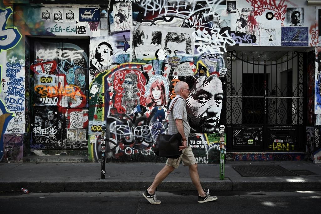 Francia. Un hombre camina sobre un mural graffitti en la antigua casa de cantante Serge Gainsbourg en París (AFP)