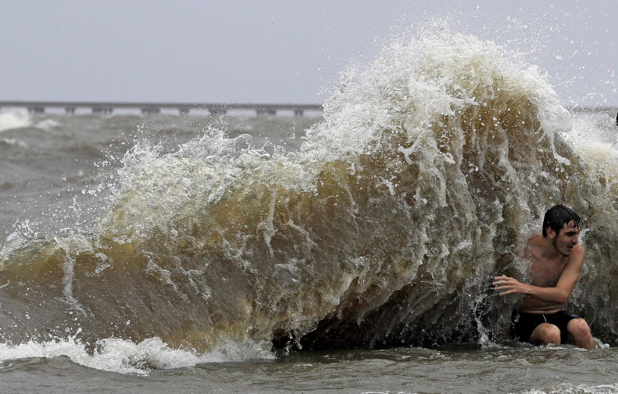 Estados Unidos. Un hombre es golpeado por una ola cuando los vientos de la tormenta tropical Barry empujan el agua del lago Pontchartrain. (AP)