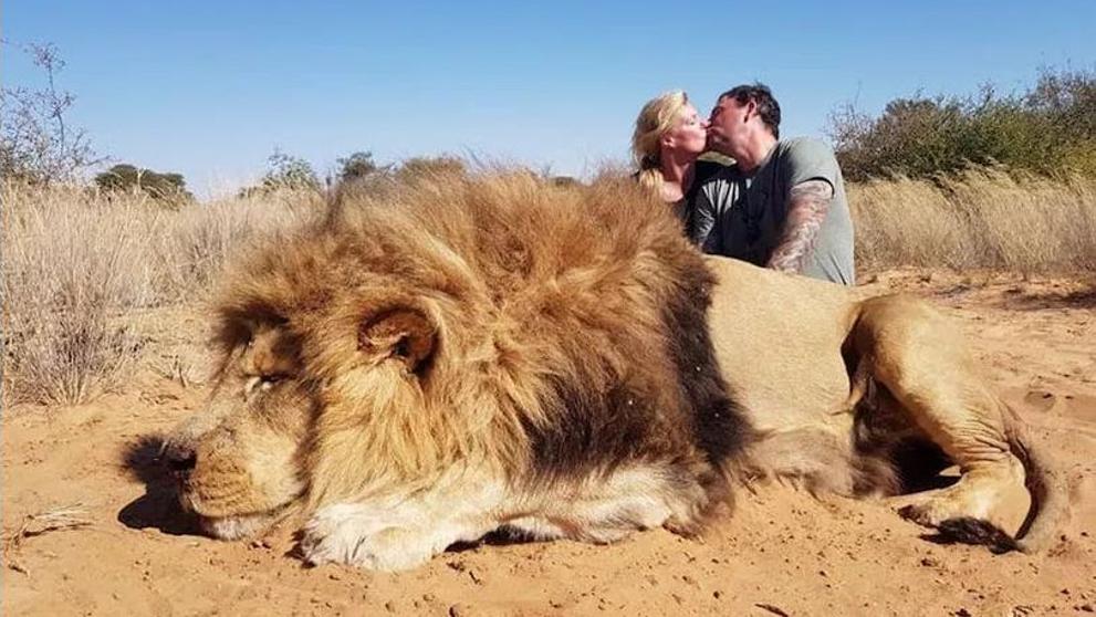Foto de unos turistas con un león como trofeo de caza (Especial).