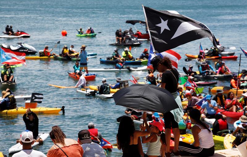 Los manifestantes acudieron en tablas de surf y motos acuáticas para exigir la renuncia del gobernador de Puerto Rico, Ricardo Rosselló. (EFE)