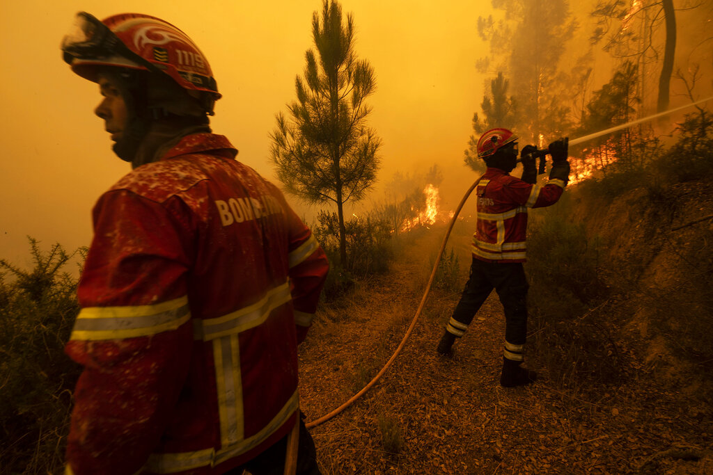 Bomberos intentando extinguir un incendio forestal en la localidad de Chaveira, Portugal. (AP Foto/Sergio Azenha)
