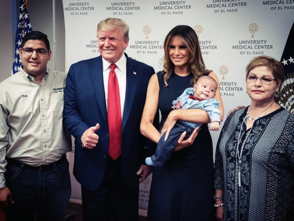 Donald Trump y Melania sonríen en una foto junto con un bebé sobreviviente del tiroteo en El Paso (AFP)