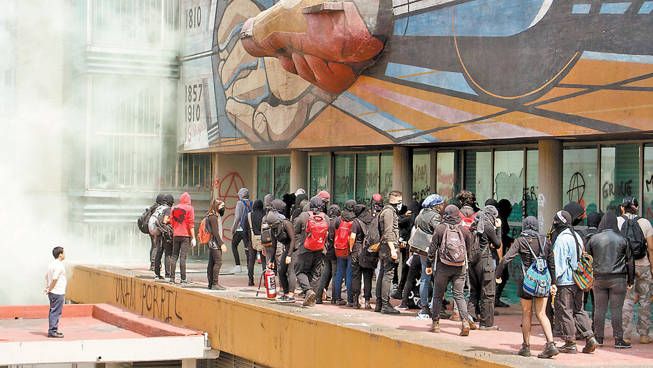 En su avance hacia el edificio principal, los agresores usaron piedras, palos y petardos. (Rogelio Morales/Cuartoscuro)