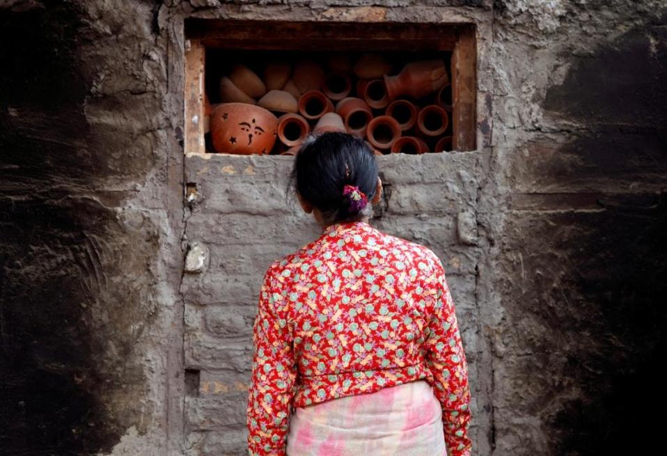 Nepal. Artesana observa cocerse los jarrones de cerámica dentro de un horno en Bhaktapur (Reuters)