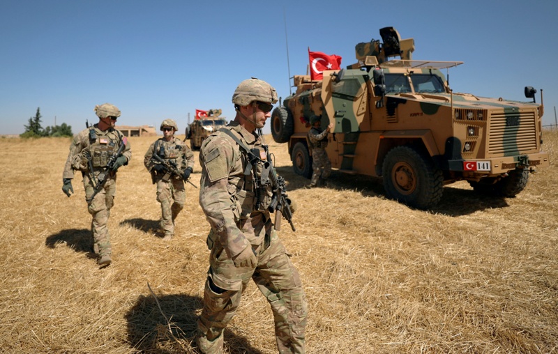 Soldados estadunidenses caminan por un campo de Tel Ayad, en Siria. (Archivo)