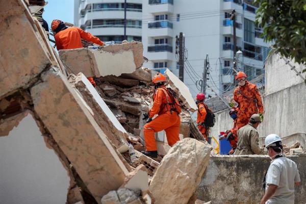 Rescatistas y bomberos asisten al sitio donde se derrumbó el edificio. (Reuters)