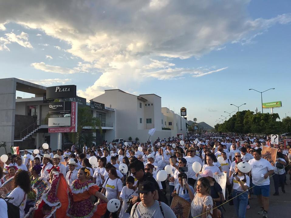 Los manifestantes marchan vestidos de blanco.