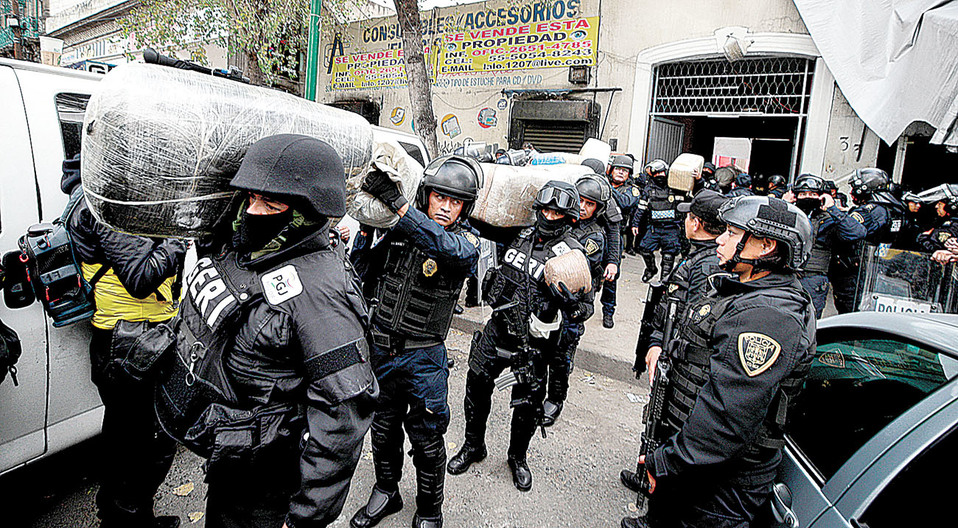 Policías cargan parte de la droga que hallaron en el predio de Peralvillo. (Cuartoscuro)