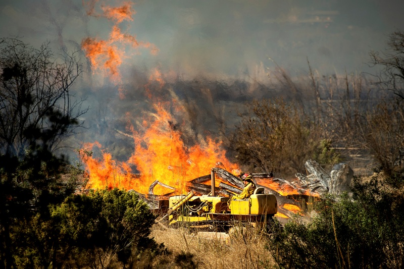 Un bombero a bordo de un equipo de maquinaria pesada crea un cortafuegos mientras se aproxima el incendio María en los alrededores de Santa Paula./ AP