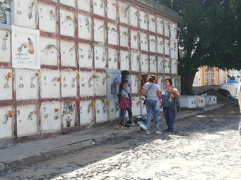 En familia, dejan ofrenda en su lugar de descanso. (ELSA GUTIÉRREZ)
