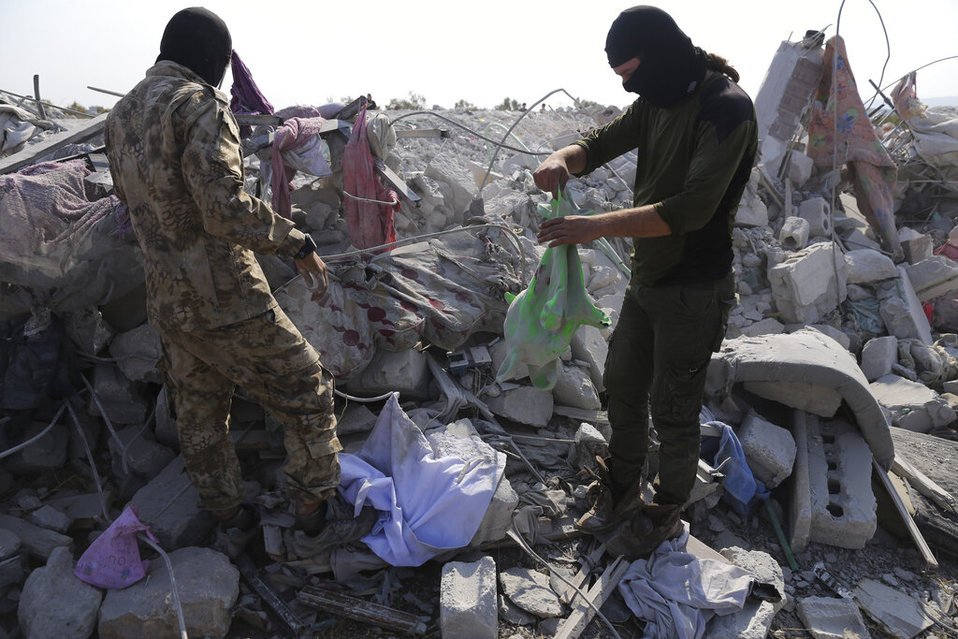 Personas observan destrozo después del ataque hacia el líder del Estado Islámico, Al Baghdadi. (AP / Archivo)