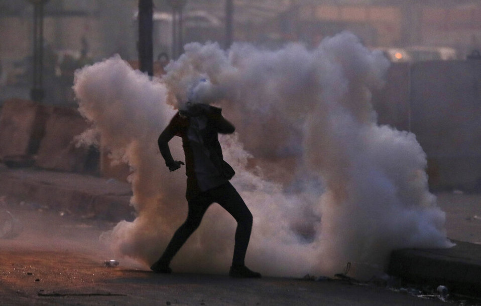 Un manifestante antigubernamental se ve rodeado por una nube de gas lacrimógeno lanzado por la policía en Bagdad. (AP)