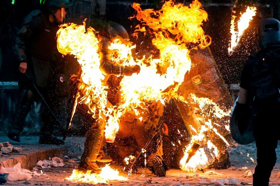 Chile. Una bomba de gasolina alcanza a un policía durante las protestas en Santiago. (AFP)