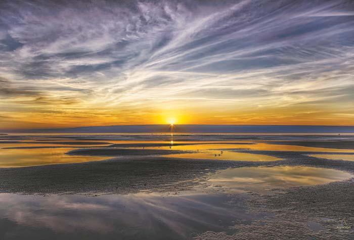 Foto tomada en el atardecer con marea baja en una marisma arenosa, en el sur de Texas.