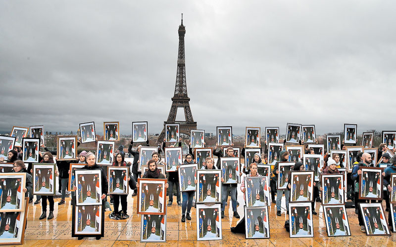 Activistas portan retratos del presidente Macron para manifestarse en contra de su papel en la Cumbre del Clima. (AP)