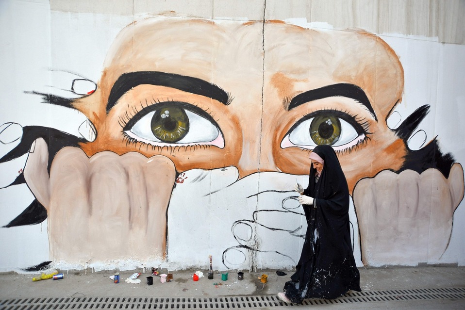 Irak. Una manifestante realiza un mural durante las protestas antigubernamentales en Najaf. (AFP)