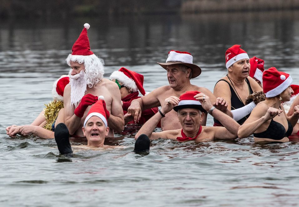 Los miembros del club de natación Berliner Seehunde (focas de Berlín) toman su tradicional baño navideño en el lago Orankesee. (AFP)