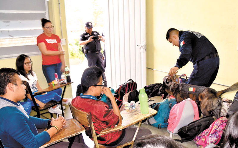 Un policía revisa las mochilas en secundaria del Edomex. (Especial)