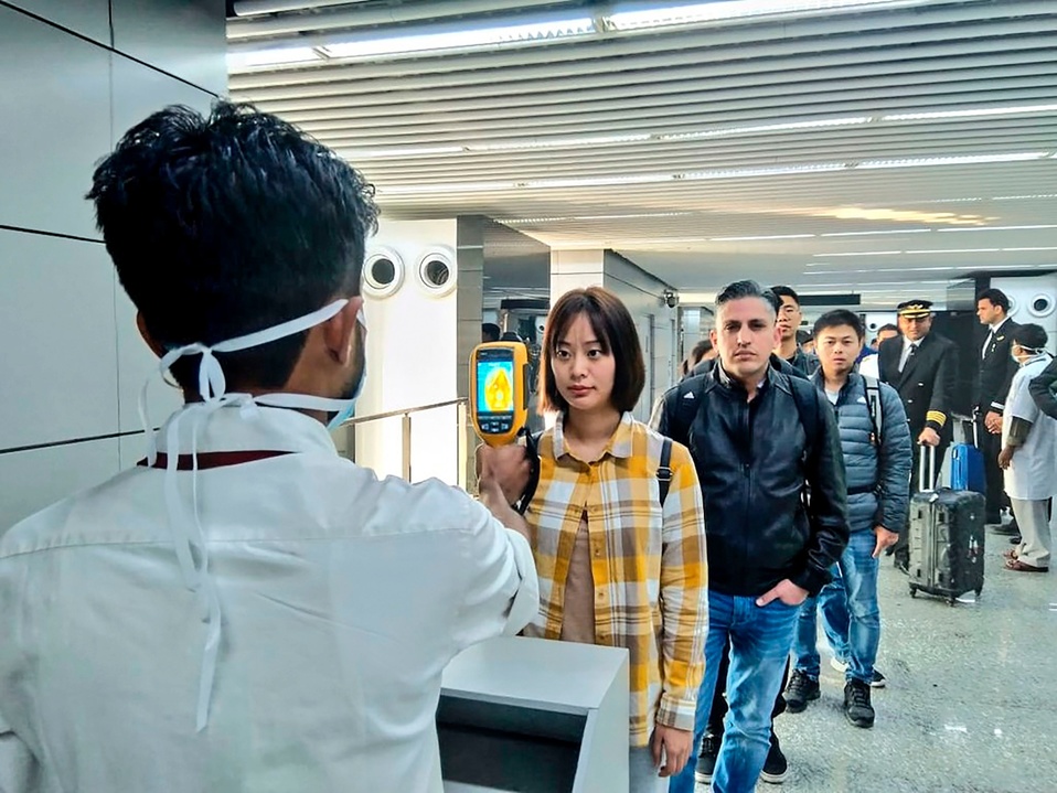 Autoridades en el aeropuerto de la India revisan a pasajeros provenientes de China y Hong Kong con una cámara termográfica. (AFP)