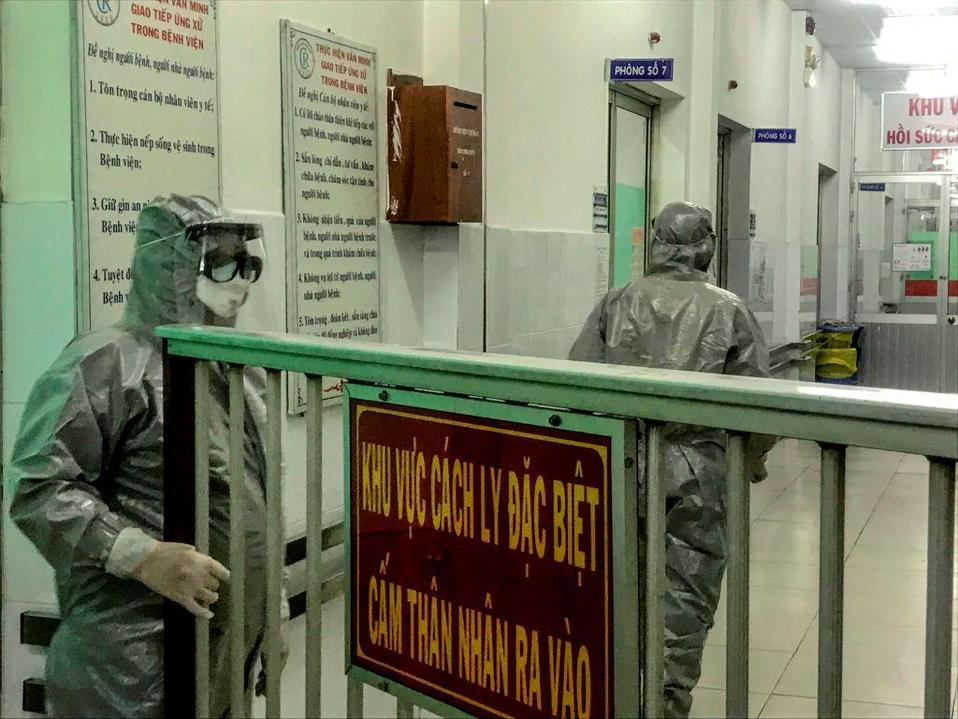 Médicos ingresan a un área de aislamiento para visitar dos casos de infección por coronavirus (AFP)
