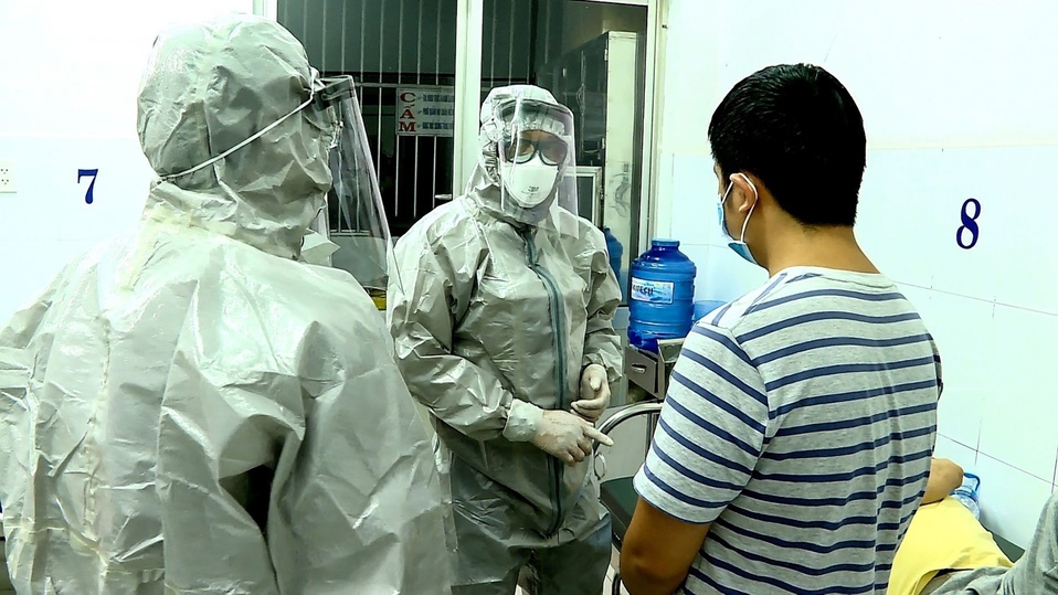 Personal médico en Vietnam interactúa con dos pacientes que dieron positivo a coronavirus y que están en aislamiento. (AFP)