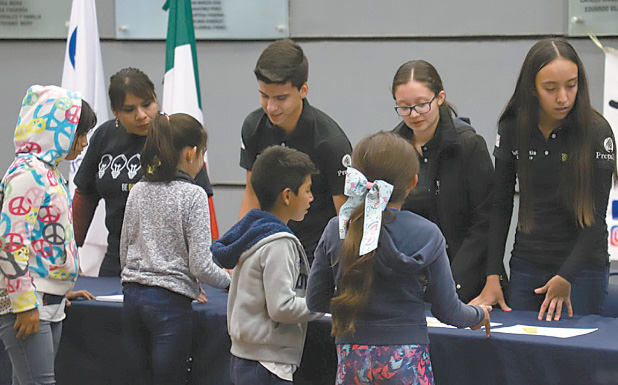 Alumnos de preparatoria del Tec de Monterrey, Campus Laguna, hacen entrega de reconocimiento a los niños. (Cortesía)
