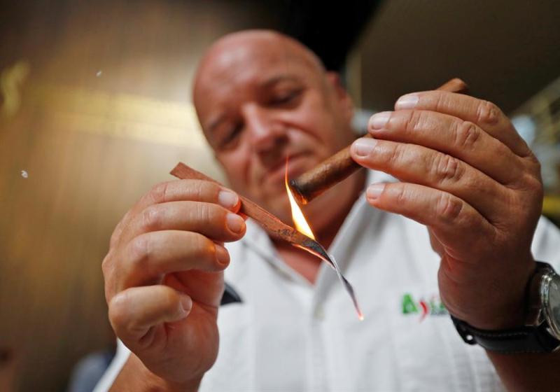 Un hombre enciende un puro durante la apertura del XXII Festival del Habano. (EFE)