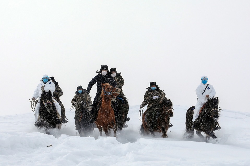 China. Policías con máscaras protectoras montan a caballo para visitar a residentes que viven en áreas remotas  en Altay. (AFP)