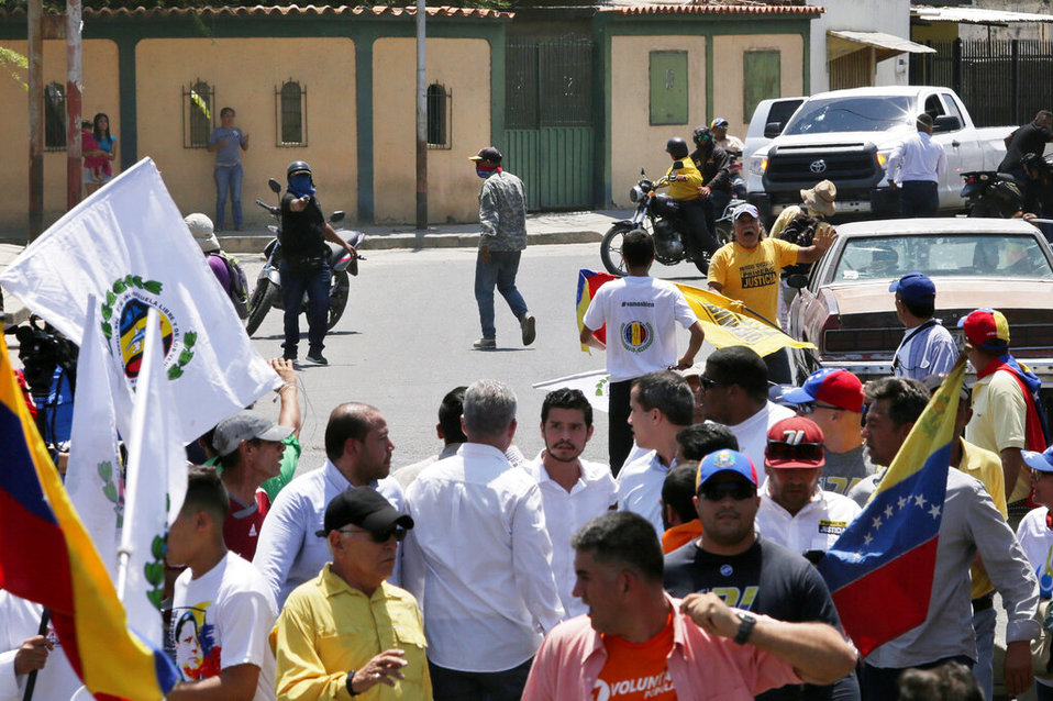 Una fotografía de la confrontación muestra a un sujeto enmascarado que apunta una pistola. (AP)