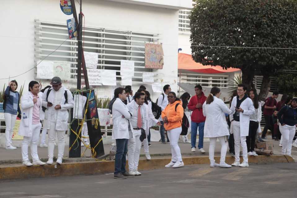 "Mochila abierta y credencial en mano", piden los estudiantes a sus compañeros para dejarlos pasar a las áreas universitarias. (Melanie Torres)