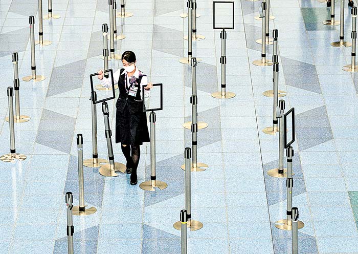 Una empleada de aerolínea usa cubrebocas en la terminal de Tokio. Philip Fong/AFP