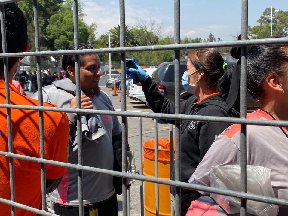 Servicio médico utilizando pistolas para revisar la temperatura del personal del festival.