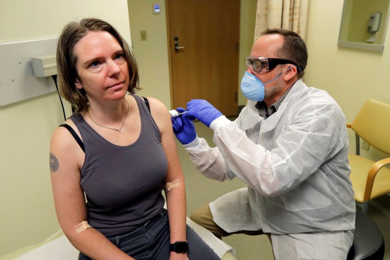 Un farmacéutico aplica a Jennifer Haller la primera dosis de una prueba clínica para una posible vacuna contra el Covid-19. (AP)