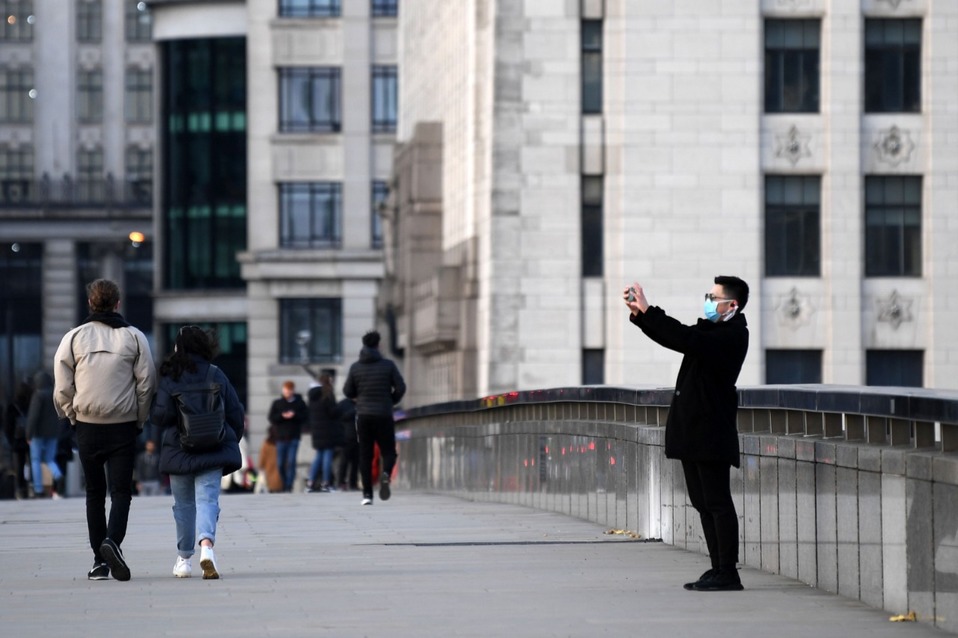 Un hombre con una máscara protectora en el Puente de Londres. Reino Unido le solicitó a sus habitantes no visitar las costas o campos por temor a prop