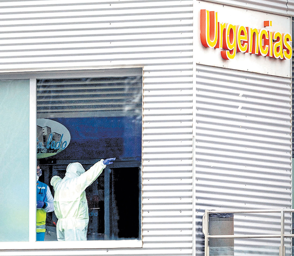 Sanitarios desinfectan sus trajes en un hospital de Alcalá de Henares. (A. Di Lolli)