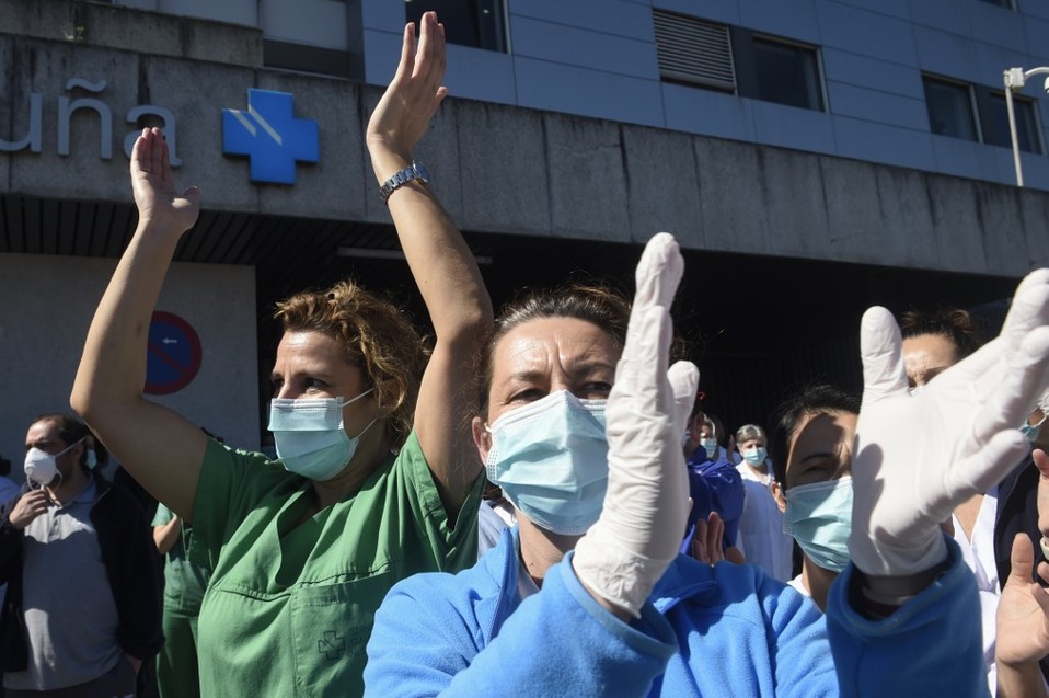 España. El personal de salud aplaude en agradecimiento a los ánimos recibidos por la policía local y la Guardia Civil. (AFP)