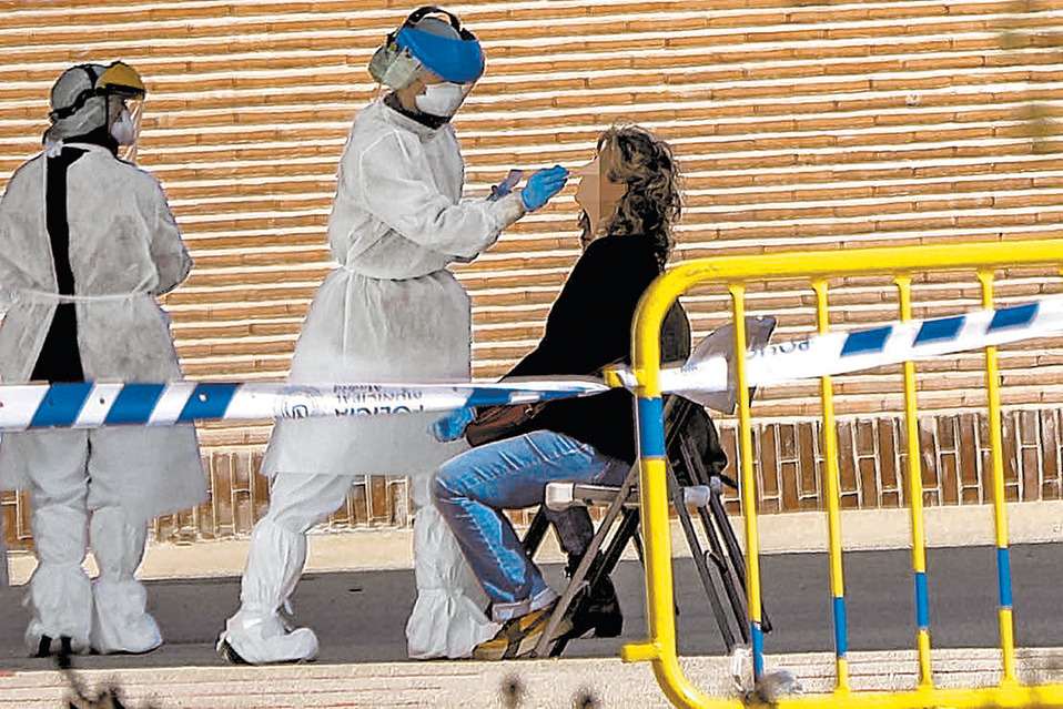 Realización de un test de diagnóstico por parte de dos trabajadores sanitarios. (El Mundo)