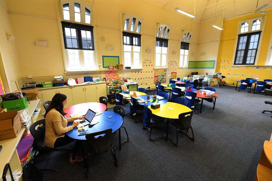 En una escuela vacía de Melbourne, una maestra da clases en línea luego de que el primer ministro australiano adelantara las vacaciones escolares. (EF