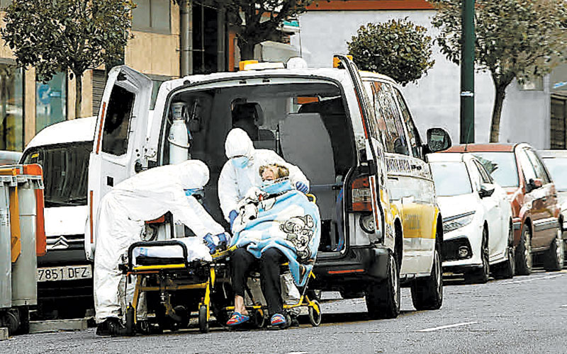 Personal sanitario, recogiendo en una ambulancia a una persona, ayer, en Valladolid.  (Juan Miguel Lostau)