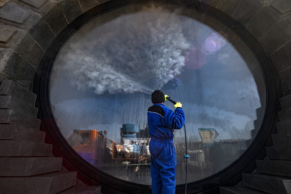 República Checa. Un trabajador desinfecta una ventana a lo largo de la orilla del río Moldava. (AFP)