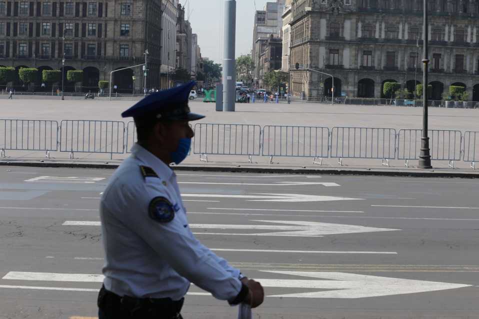 Coronavirus. Policía con cubrebocas camina a un costado de la plancha del Zócalo de la CdMx.
