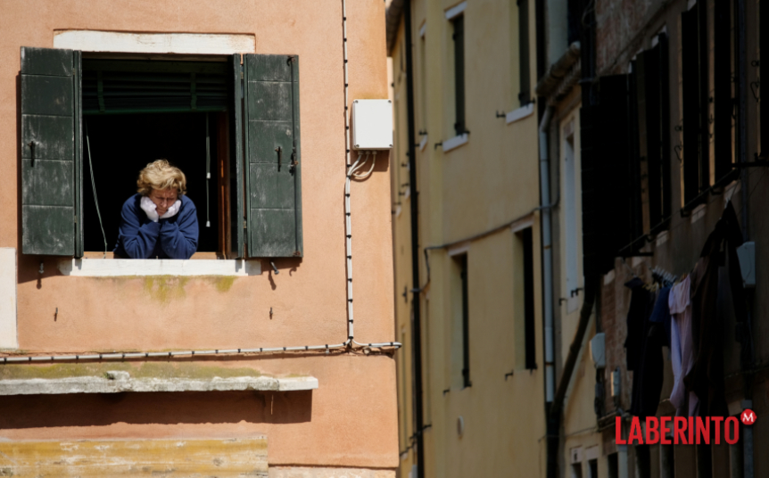 Una mujer mira hacia la calle desde un balcón de Italia. (Foto: Manuel Silvestri | Reuters)