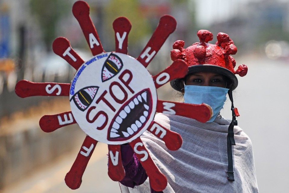 India. Un voluntario sostiene una pancarta de concientización sobre el coronavirus. (AFP)