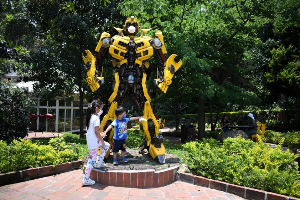 Guatemala. Dos niños con cubrebocas juegan al lado de una estatua de Bumblebee con máscara facial por el coronavirus. (AFP)