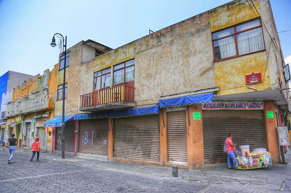 Una trabajadora informal vende en su puesto ambulante afuera de un negocio cerrado. (Andrés Lobato)