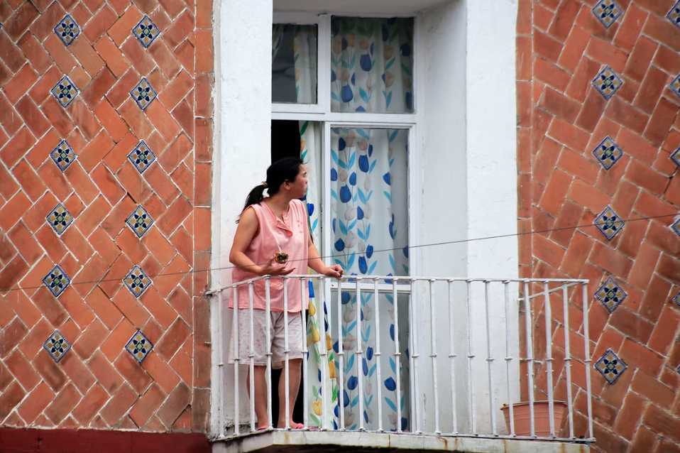Desde el confinamiento, una mujer mira la calle en su balcón. (Andrés Lobato)